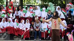Sejumlah pelajar bersiap menyambut kedatangan Raja Salman bin Abdulaziz di sekitar Istana Bogor, Rabu (1/3). 21 dentuman meriam dan kibaran bendera kedua negara mewarnai sambut Raja Salman. (Liputan6.com/Helmi Fithriansyah)
