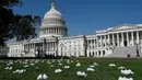 Serikat perawat Amerika Serikat (AS) meletakkan 164 pasang sepatu putih di luar US Capitol di Washington, DC pada Selasa (21/7/2020). Sepatu-sepatu itu melambangkan para perawat yang tewas akibat covid-19 dan menuntut Senat bertindak cepat melindungi perawat di garis depan. (Olivier DOULIERY/AFP)