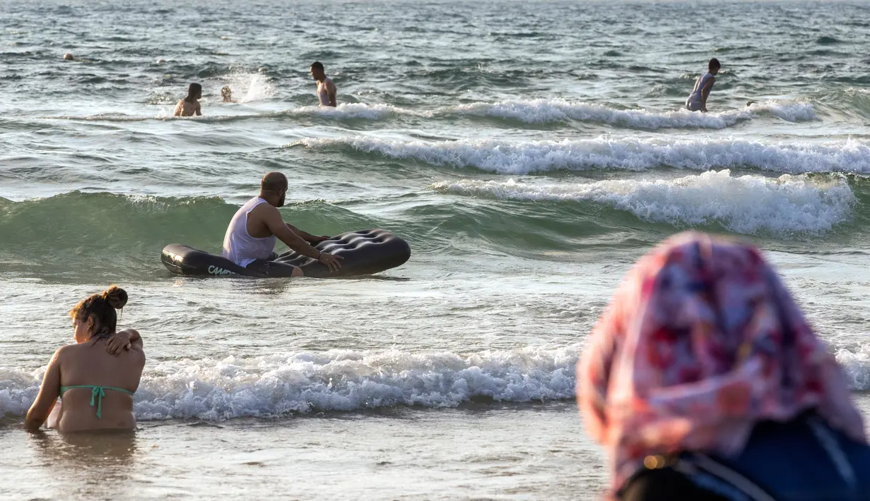 Sejumlah muslim bermain ombak saat menikmati libur lebaran di pantai laut Mediterania di Tel Aviv, Israel, 26 Jni 2017. (AFP PHOTO / JACK GUEZ)