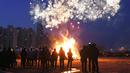 Peserta menyaksikan kembang api menjelang perayaan "Jeongwol Daeboreum" di Seoul, Korea Selatan (1/3). Jeongwol Daeboreum merupakan perayaan hari libur tradisional Korea untuk merayakan bulan purnama pertama kalender lunar. (AFP Photo/Jung Yeon-je)