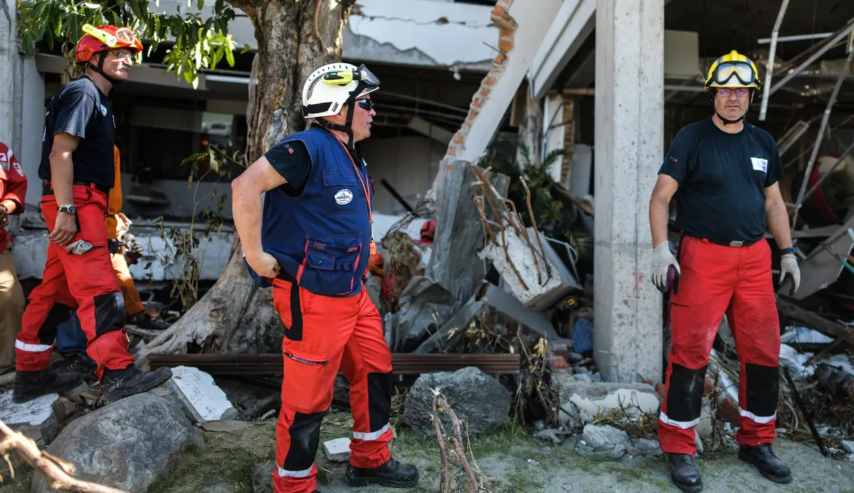 Anggota dari Pemadam Kebakaran Darurat Internasional Prancis bersiap memasuki hotel Mercure untuk mencari korban gempa dan tsunami di Palu, Sulteng (4/10). Sebanyak 1.411 orang telah dikonfirmasi tewas akibat bencana tersebut. (AFP Photo/Mohd Rasfan)