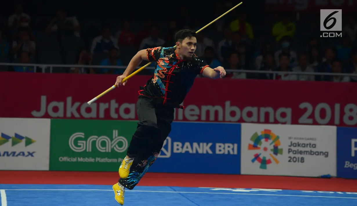 Atlet Wushu Indonesia Hulaefi Achmad beraksi pada laga final Men's Daoshu dan Gunshu Asian Games 2018 di JIexpo,Hall B, Kemayoran, Jakarta, Selasa (21/8). Achmad berhasil meraih perunggu dan sukses merebut total 19,41 poin. (Merdeka.com/Imam Buhori)