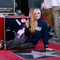 Penyanyi Avril Lavigne berpose di atas bintang barunya di Hollywood Walk of Fame setelah upacara  penghargaan untuknya, di Los Angeles, Rabu (31/8/2022). Pemilik nama lengkap Avril Ramona Lavigne telah memecahkan rekor dengan sederet lagu-lagu hitnya. (Emma McIntyre/Getty Images/AFP )