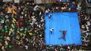 Pegulat amatir India bertarung saat mengikuti kompetisi untuk menyambut perayaan Diwali di Kolkata, India (18/10). Pertandingan gulat ini digelar di tengah jalan yang padat di daerah Kolkata. (AFP Photo/Dibyangshu Sarkar)