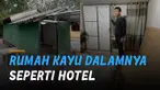 Aksi seorang pria memperlihatkan rumah kayu yang beda dari lainnya.
