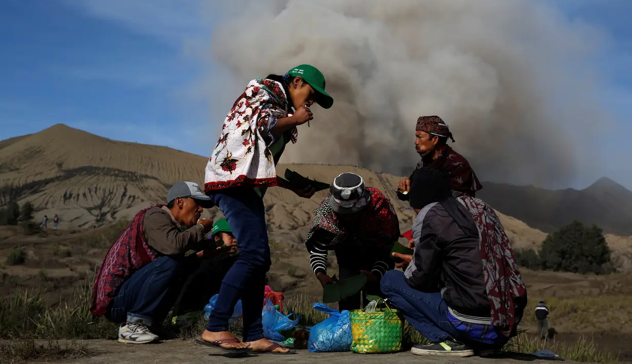 Warga suku Tengger beristirahat makan sebelum mengikuti upacara Kasada di gunung Bromo, Probolinggo, Rabu (20/7). Perayan Kasada suku Tengger Bromo akan digelar 20 - 21 Juli 2016. (REUTERS / Beawiharta)
