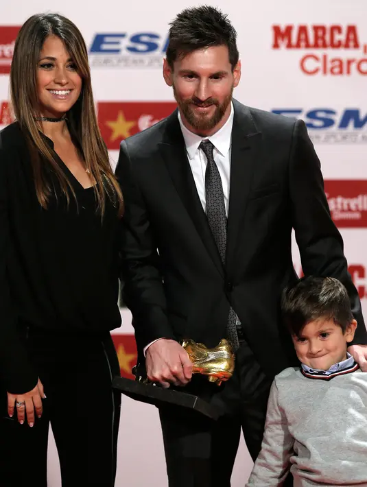 Penyerang Barcelona, Lionel Messi berpose dengan istrinya Antonella Roccuzzo dan putranya Thiago usai meraih sepatu emas di Barcelona, Spanyol (24/11). (AP Photo/Manu Fernandez)