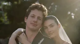 Keduanya tampil serasi dalam balutan busana pengantin. Charlie Puth mengenakan setelan hitam dengan atasan jas kasual dan aksen renda putih dibuat oleh Bode. Sementara itu, Brooke mengenakan gaun putih tube dengan teil panjang dan veil pendek di atas rambut sanggulnya karya Danielle Frankel Studio. (Liputan6.com/IG/@charlieputh)