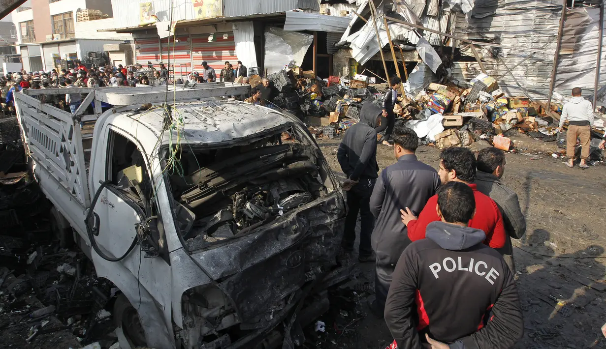 Sebuah mobil rusak akibat ledakan bom di pasar sayur Jumila di Baghdad, Irak (8/1). Terjadi sebuah serangan bom bunuh diri di bagian timur dari ibukota Irak, Baghdad yang menewaskan belasan orang. (AFP/Sabar Arar)
