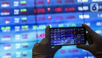 Karyawan mengambil gambar layar Indeks Harga Saham Gabungan (IHSG) di Bursa Efek Indonesia, Jakarta, Jumat (22/1/2021). Sebanyak 111 saham menguat, 372 tertekan, dan 124 lainnya flat. (Liputan6.com/Johan Tallo)