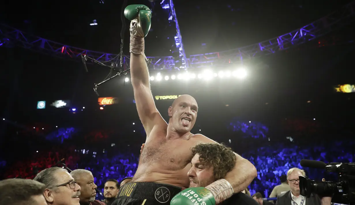 Petinju Inggris Tyson Fury berselebrasi usai mengalahkan petinju AS Deontay Wilder pada pertandingan tinju kelas berat WBC di Las Vegas (23/2/2020). Tyson Fury dinyatakan menang TKO atas Wilder. (AP Photo/Isaac Brekken)