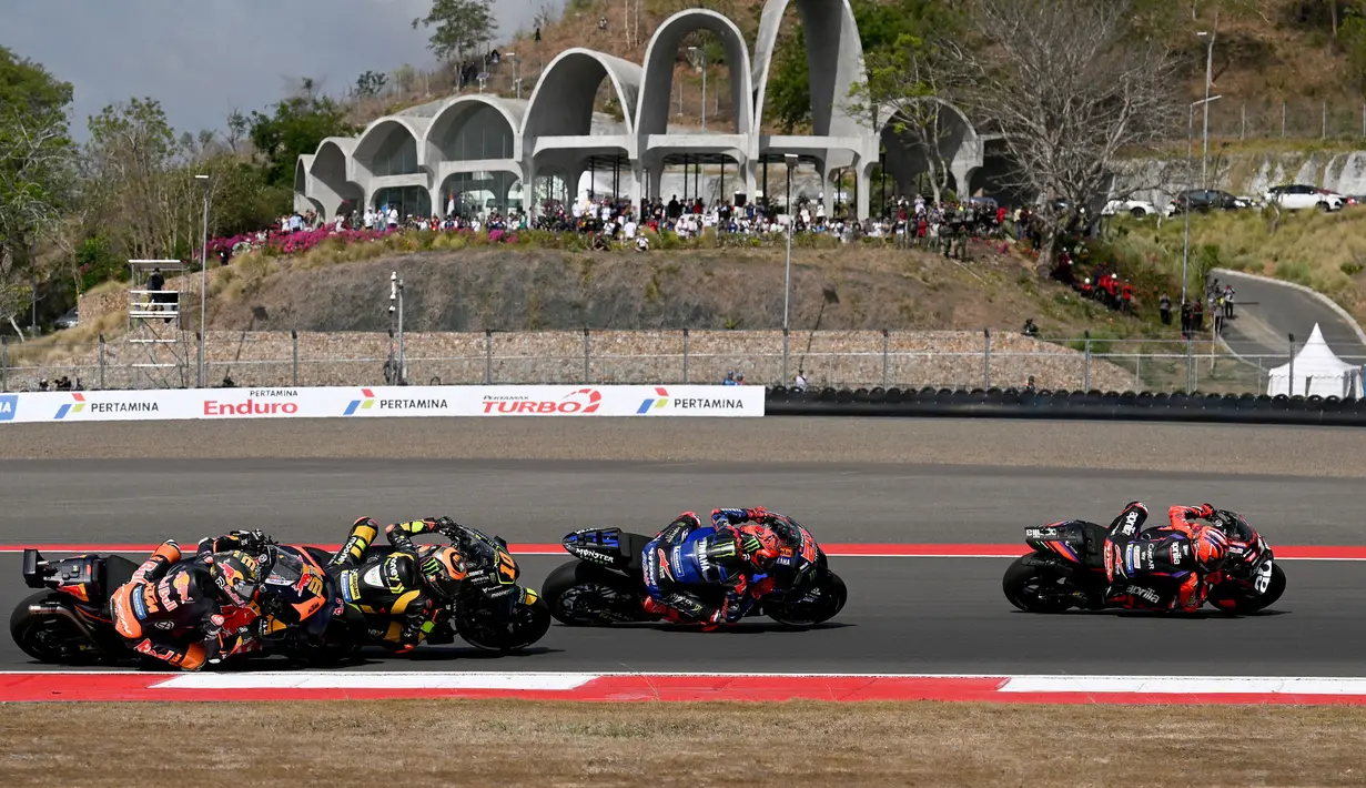 <p>Sejumlah pembalap memacu motornya saat MotoGP Indonesia 2023 yang berlangsung di Sirkuit Mandalika, Lombok, NTB, Minggu (15/10/2023). Berbeda dengan tahun lalu, balapan pada tahun ini diwarnai dengan cuaca cerah dan terik. Selain itu, beberapa kekurangan baik infrastruktur maupun pelayanan yang sempat banyak mendapatkan kritikan mampu diperbaiki pada tahun ini. (AFP/Sonny Tumbaleka)</p>