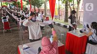 Peserta memberikan berkas sebelum mengikuti proses Tes Standar Kompetensi Dasar (SKD) CPNS di BKN, Jakarta, Kamis (2/9/2021). Sebanyak 800 peserta mengikuti tes yang dibagi dua sesi dan menerapkan protokol kesehatan yang ketat. (Liputan6.com/Herman Zakharia)