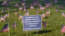 Aktivis dari COVID Memorial Project meletakkan ribuan bendera Amerika berukuran kecil di di halaman National Mall di Washington, Selasa (22/9/2020). Ribuan bendera itu menandai 200 ribu nyawa yang hilang akibat virus corona Covid-19 di Amerika Serikat. (AP Photo/J. Scott Applewhite)