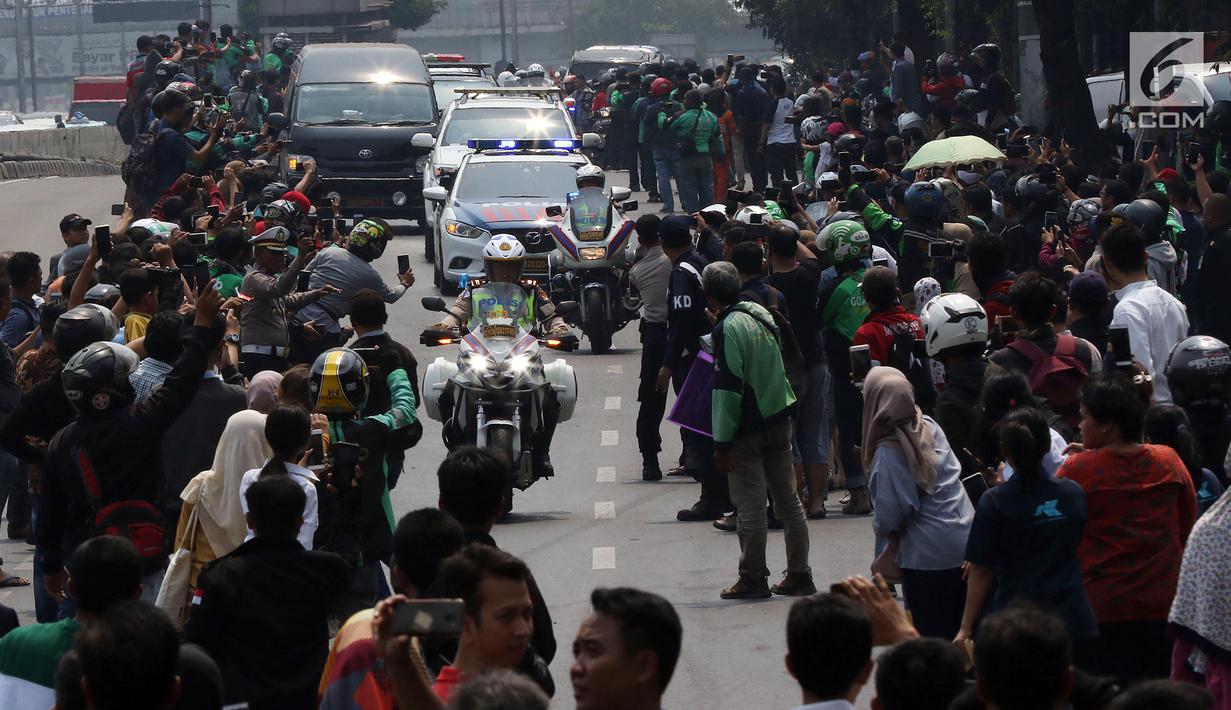 Iring-iringan mobil jenazah yang membawa almarhum Presiden ke-3 RI, BJ Habibie melintasi Jalan Gatot Subroto menuju TMP Kalibata, Jakarta, Kamis (12/9/2019). Warga secara khusus meluangkan waktu menyambut jenazah BJ Habibie untuk memberikan penghormatan terakhir. (Liputan6.com/Johan Tallo)