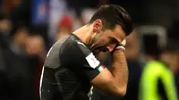 Kiper Italia, Gianluigi Buffon mengusap air matanya seusai menjamu Swedia pada playoff zona Eropa di Stadion San Siro, Selasa (14/11). Buffon tak kuasa menahan tangis setelah timnya gagal lolos ke Piala Dunia 2018. (AP/Luca Bruno)