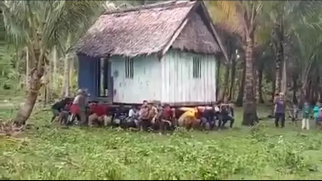 Warga di Desa Laanobhake Maligano Kabupaten Muna memikul sebuah rumah panggung, diduga anara pemilik rumah dan pemilik lahan berbeda pilihan pada momen Pilkades.(Liputan6.com/Ahmad Akbar Fua)