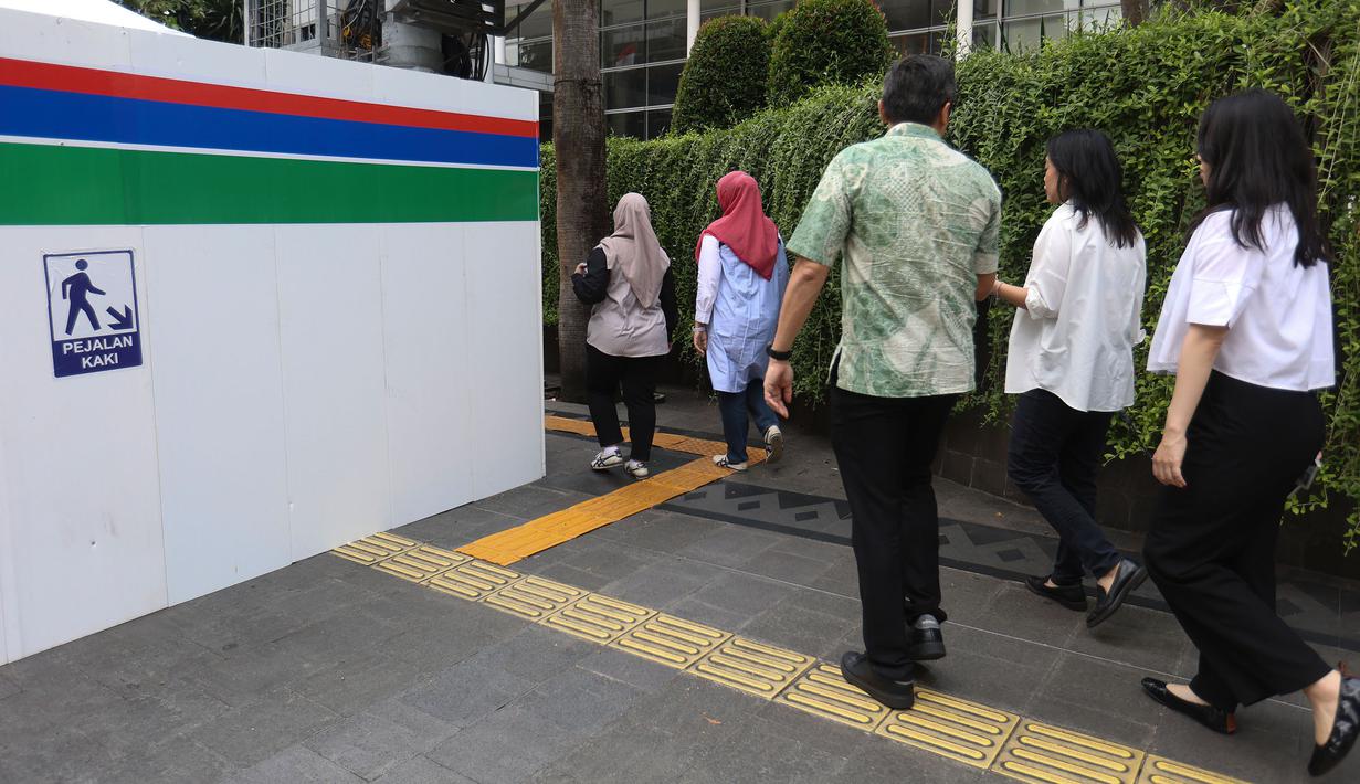 Pengguna jalan diharapkan untuk berhati-hati dan mengikuti rambu lalu lintas yang telah disiapkan. Tampak dalam foto, warga melintas di area pedestrian kawasan Jalan MH Thamrin, Jakarta, Senin 20 April 2026. (Kapanlagi.com/Budy Santoso)