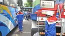 Petugas mempersiapkan selang gas untuk Bus BRT Trans Semarang di Pelataran Parkir Patra Jasa Semarang, Rabu (9/1). Sejumlah bus mulai beralih menggunakan Bahan Bakar Gas (BBG)  pada bus sedang (medium) . (Liputan6.com/Gholib)