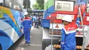 Petugas mempersiapkan selang gas untuk Bus BRT Trans Semarang di Pelataran Parkir Patra Jasa Semarang, Rabu (9/1). Sejumlah bus mulai beralih menggunakan Bahan Bakar Gas (BBG)  pada bus sedang (medium) . (Liputan6.com/Gholib)