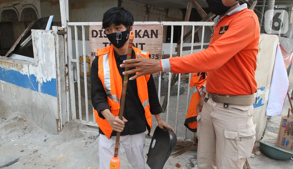 Petugas Satpol PP (kanan) menghukum warga pelanggar PSBB yang terjaring razia masker di Jalan Tanjung Duren Raya, Jakarta, Jumat (11/9/2020). Petugas Satpol PP gencar melakukan razia masker menyusul kasus COVID-19 di DKI Jakarta yang terus meningkat. (merdeka.com/Imam Buhori)