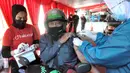 Paramedis menyuntikkan vaksin COVID-19 secara drive thru kepada pengendara sepeda motor di GOR Pajajaran, Kota Bogor, Jawa Barat, Rabu (17/3/2021). Kegiatan ini menargetkan 600 warga per hari dan berlangsung hingga tiga bulan ke depan. (merdeka.com/Arie Basuki)