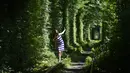 <p>Seorang gadis berjalan di sepanjang bekas rel kereta api atau disebut 'Tunnel of Love' yang dikelilingi pohon dekat desa Ukraina Klevan, Rivno, (6/8). Terowongan cinta yang panjangnya sekitar lima km adalah fenomena botani. (AFP Photo/Sergei Supinsky)</p>
