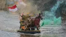 Peserta berparade dengan perahu yang terbuat dari sampah daur ulang mengikuti Festival Perahu Cilung 2025 di kawasan jalan Inspeksi Kali Ciliwung, Pancoran, Jakarta Selatan, Minggu (28/9/2025). (merdeka.com/Arie Basuki)