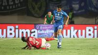 Pemain Bali United, Privat Mbarga (kiri) terjatuh saat perebutan bola dengan pemain Persib Bandung, Rachmat Irianto pada laga leg kedua semifinal Championship Series BRI Liga 1 2023/2024 di Stadion Si Jalak Harupat, Soreang, Kabupaten Bandung, Sabtu (18/5/2024). (Bola.com/Abdul Aziz)