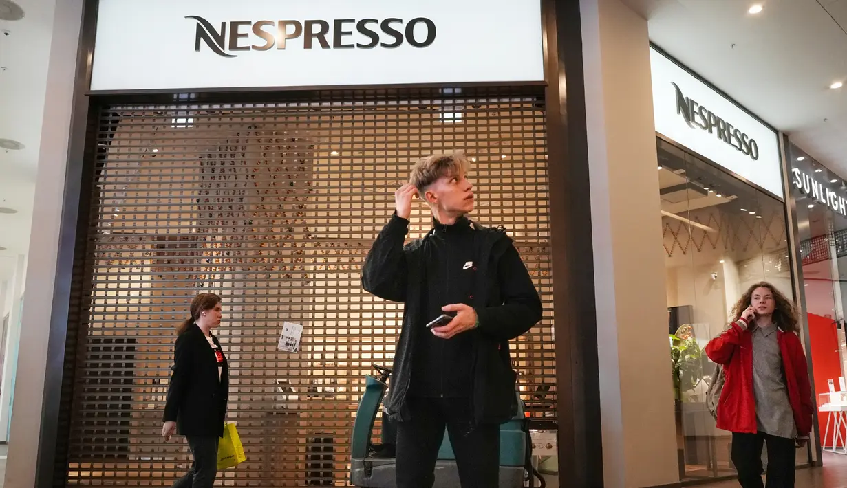 Pengunjung berjalan melewati toko Nespresso yang tutup akibat sanksi barat di sebuah pusat perbelanjaan di St. Petersburg, Rusia, Selasa, 31 Mei 2022. Banyak perusahaan Barat telah meninggalkan Rusia setelah dimulainya invasi Moskow ke Ukraina. (AP Photo/Dmitri Lovetsky)