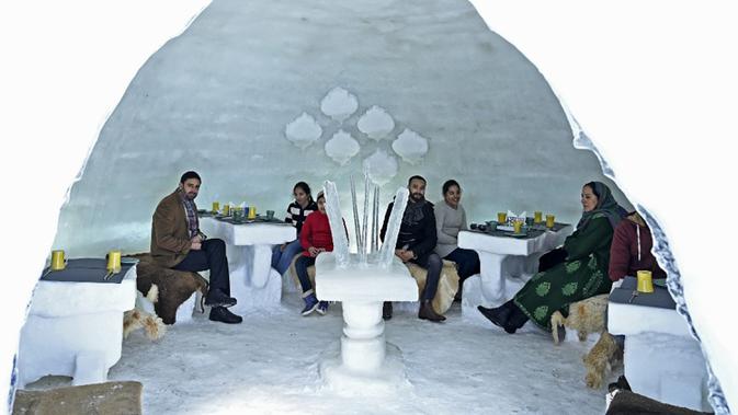 Para tamu terlihat dalam Igloo yang terbuat dari salju di resor ski di Gulmarg, sekitar 55 km utara Srinagar, Jammu dan Kashmir, India, 25 Januari 2021. Gulmarg menjadi favorit penggemar olahraga pemacu adrenalin seperti ski, papan luncur es, dan aktivitas salju lainnya. (Tauseef MUSTAFA/AFP)