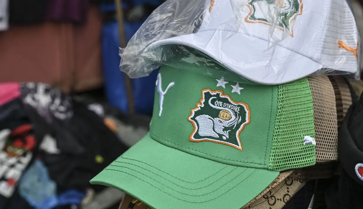Topi berlogo Pantai Gading dijual di salah satu pasar Abidjan, pusat kota Pantai Gading menjelang Piala Afrika 2023 pada Sabtu (06/01/2024) waktu setempat.. (AFP/Issouf Sanogo)