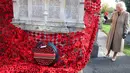 Ratu Inggris, Camilla, memasang bunga poppy terakhir untuk melengkapi rangkaian 10.000 bunga poppy yang menghiasi menara gereja di Gereja St. Bartholomew di Corsham, Inggris, pada Selasa 28 Oktober 2025. Kunjungan ini menjadi bagian dari kunjungan Ratu Inggris, Camilla, ke The Poppy Project. (Chris Jackson/POOL/AFP)