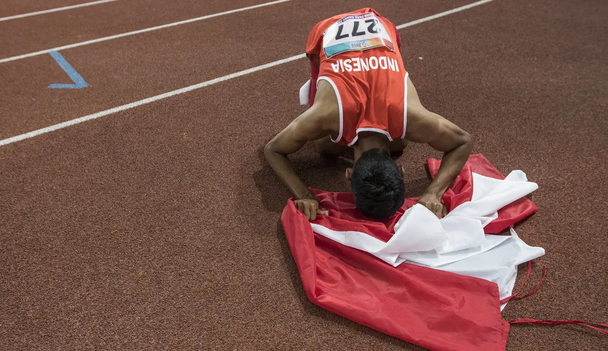 Pelari Indonesia, Sapto Yogo Purnomo, melakukan sujud usai meraih medali emas cabang atletik nomor lari 200 meter T 37 Asian Para Games di SUGBK, Jakarta, Senin (8/10/2018). (Bola.com/Vitalis Yogi Trisna)