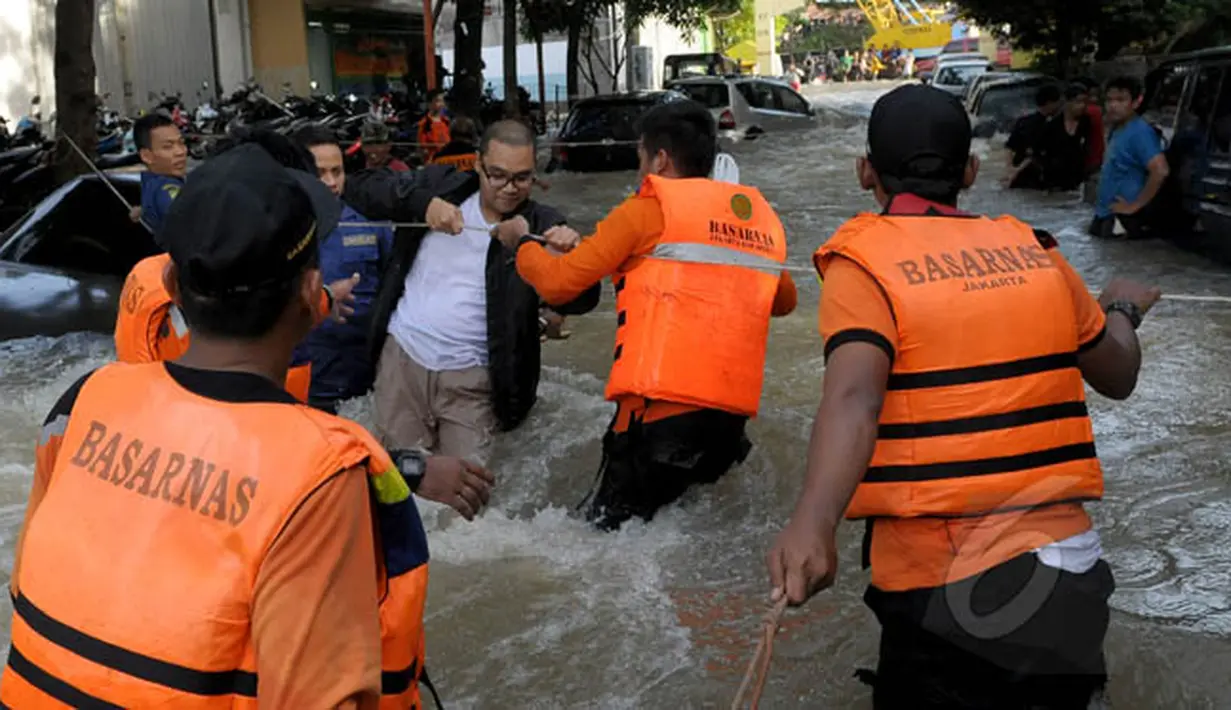 Petugas Basarnas membantu warga menyeberangi banjir di Perumahan Ciledug Indah 1, Tangerang, Selasa (10/2/2015). (Liputan6.com/Andrian M Tunay)