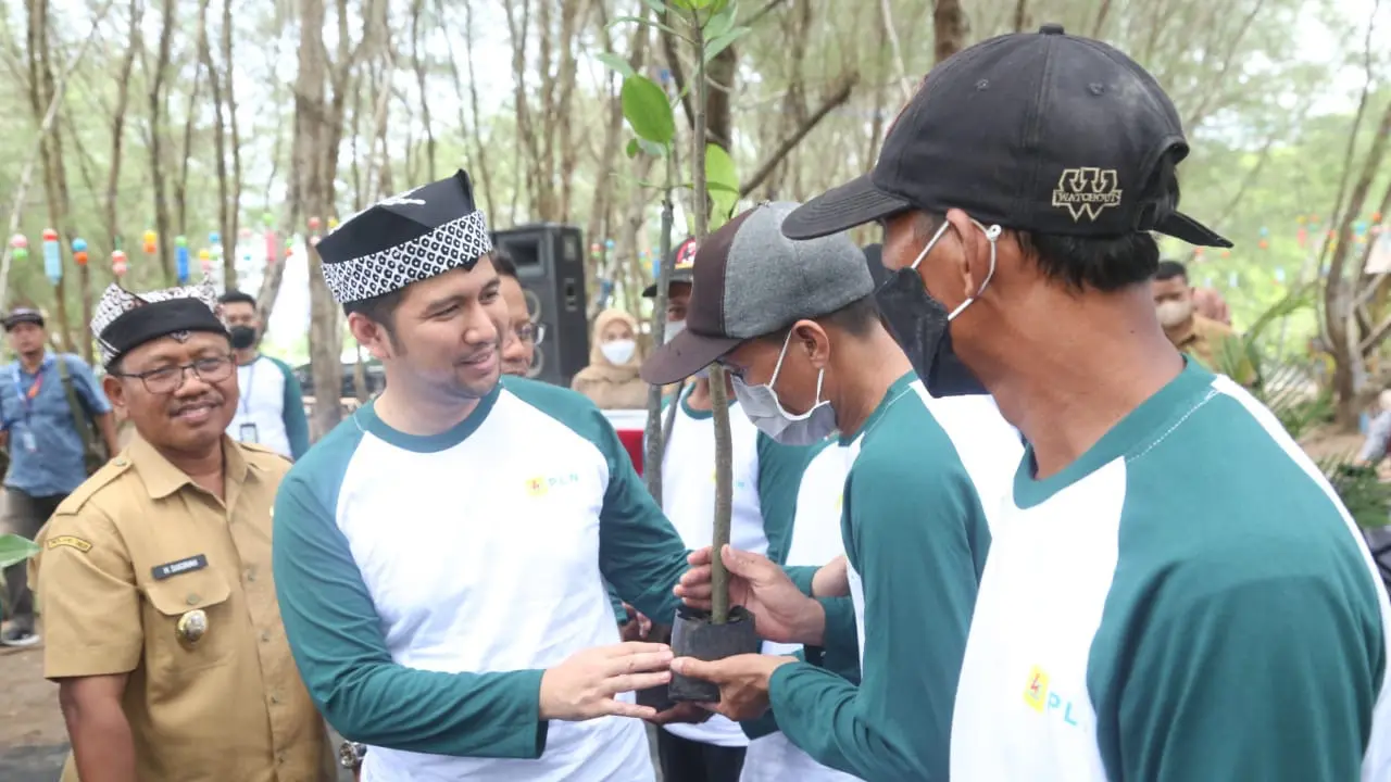 Wakil Gubernur Jawa Timur Emil Elestianto Dardak bersama Wakil Bupati Banyuwangi Sugirah menyerahkan bibit mangrove ke  warga Pantai Cemara. (Istimewa)