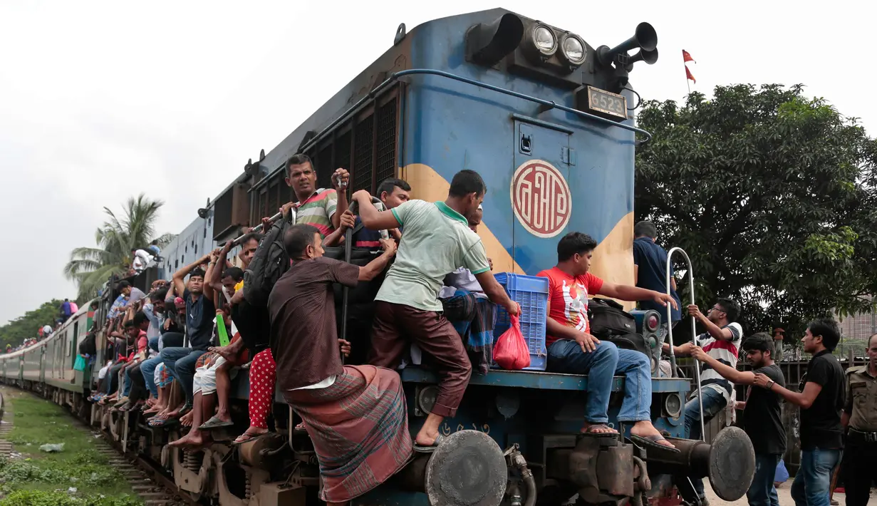 Sejumlah penumpang saat menaiki kereta api di Dhaka, Bangladesh, (22/6). Ribuan yang bekerja di Dhaka pulang ke kampung halamannya untuk merayakan lebaran bersama keluarganya. (AP Photo/A.M.Ahad)