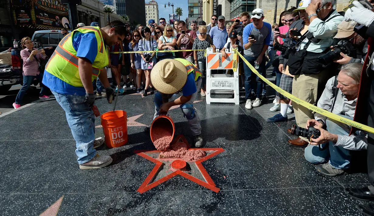 Pekerja memperbaiki Hollywood Walk of Fame milik Donald Trump usai dirusak seorang pria bernama James Lambert Otis , California, AS (26/10). Peristiwa tersebut diketahui terjadi sekitar pukul 5:45 pagi waktu setempat. (David McNew/Getty Images/AFP)