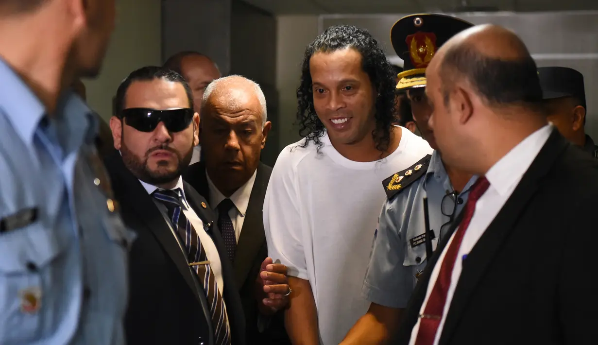 Mantan pemain timnas Brasil, Ronaldinho tiba memberikan keterangan di Asuncion's Justice Palace, ibu kota Paraguay, Jumat (6/3/2020). Ronaldinho bersama saudara laki-lakinya berurusan dengan pihak berwenang Paraguay karena menggunakan paspor palsu untuk memasuki negara itu. (Norberto DUARTE/AFP)