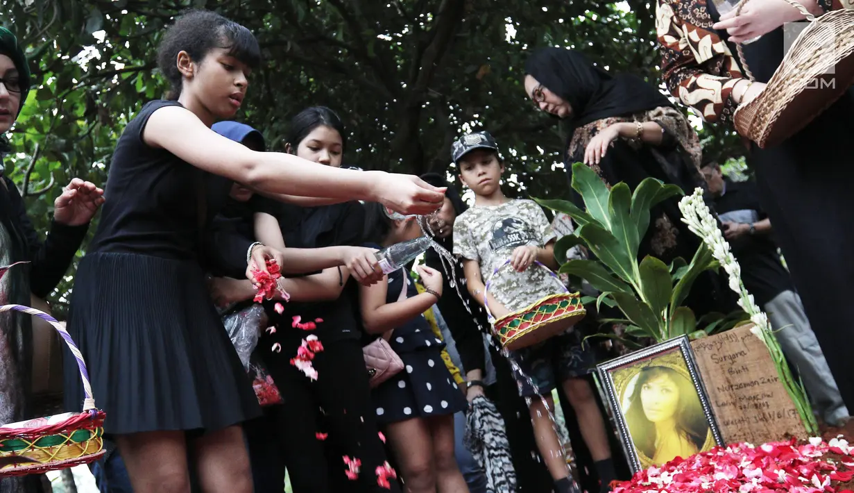Penaburan bunga di atas makam Yana Zein di TPU Gandul, Cinere, Depok, Jumat (2/6). Yana Zein meninggal pada kamis (1/6/2017), karena kanker payudara stadium VI yang dideritanya. (Liputan6.com/Herman Zakharia)