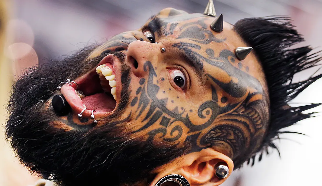 Ekspresi Emilio Gonzalez saat menunjukkan tato dan tindikannya pada hari pertama Konvensi Tattoo Frankfurt di Frankfurt, Jerman, Jumat, 21 April 2017. (AP Photo / Michael Probst)