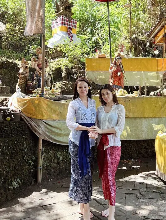 Ia juga tampil mengenakan kebaya putih dipadukan kain dan obi warna biru saat berada di Bali. [@michelleziu]