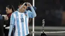 Lionel Messi melepas medali perak yang diraihnya. (AFP PHOTO/JUAN MABROMATA)