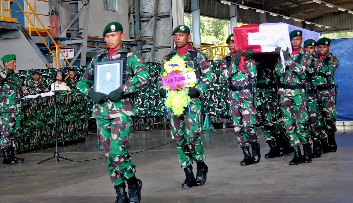 Tentara membawa peti jenazah rekan mereka yang tewas dalam serangan Kelompok Kriminal Bersenjata (KKB), Timika, Papua, (Kamis/12). Sersan Satu Handoko gugur dalam kontak senjata dengan KKB di Papua. (AP Photo/Mujiono)