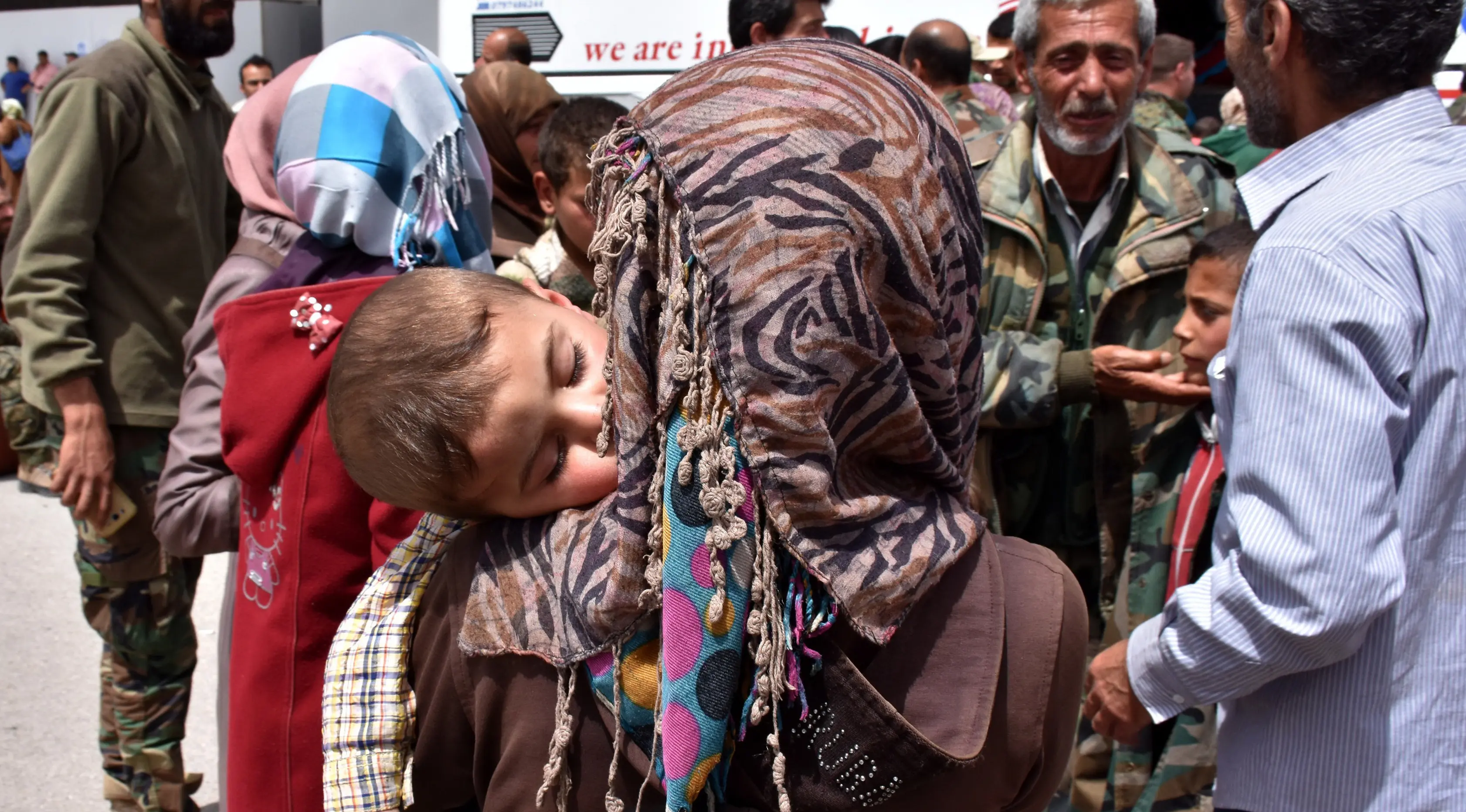 Seorang anak tertidur dalam gendongan saat berada di sebuah tempat penampungan sementara di Jibrin di pinggiran timur Aleppo, Jumat (21/4). Pengungsi adalah warga dari kota Fuaa dan Kafraya. (AFP PHOTO / George OURFALIAN)