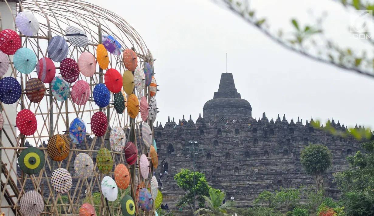 Kreasi payung tradisional nusantara mewarnai kawasan Taman Lumbini, Komplek Candi Borobudur selama Festival Payung Indonesia 2018 di Magelang, Jawa Tengah, Jumat (7/9). Festival budaya ini diselenggarakan tanpa pungutan biaya. (Liputan6.com/Gholib)