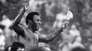 <p>Pemain sepak bola Brasil Edson Arantes do Nascimento atau Pele mengibarkan bendera Brasil dan AS saat dibawa keluar lapangan setelah pertandingan terakhirnya di Stadion Giants, East Rutherford, New Jersey, Amerika Serikat, 1 Oktober 1977. Pada akhir 1970-an, Pele bermain di Amerika Serikat untuk New York Cosmos sebelum akhirnya pensiun pada 1977. (AP Photo/Richard Drew, File)</p>