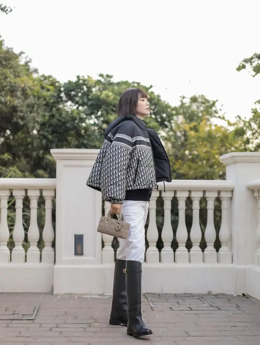 Aktris asal Hong Kong, Elva Ni tampil modis dengan padu padan Reversible Cropped Down Jacket, long pants puth, sepatu boots, dan tas Dior Lady D-Joy warna hazelnut. [Dior].