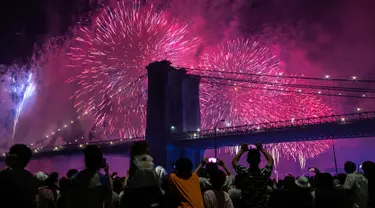 Orang-orang menyaksikan pertunjukkan kembang api di sisi timur Manhattan selama perayaan Hari Kemerdekaan Amerika Serikat atau yang dikenal sebagai Fourth of July di New York, Kamis (4/7/2019). Di Amerika Serikat sendiri, 4 Juli ditetapkan sebagai hari libur nasional. (AP Photo/Jeenah Moon)