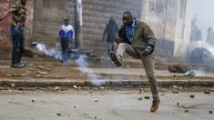 Seorang pria menendang granat gas air mata ke arah polisi selama protes di ibu kota Nairobi, Kenya Jumat (7/7/2023). Lusinan pengunjuk rasa anti-pemerintah ditangkap di Nairobi karena bagian lain negara itu juga menyaksikan demonstrasi yang diserukan oleh oposisi terhadap pajak yang baru dikenakan dan biaya hidup. (AP Photo/Brian Inganga)